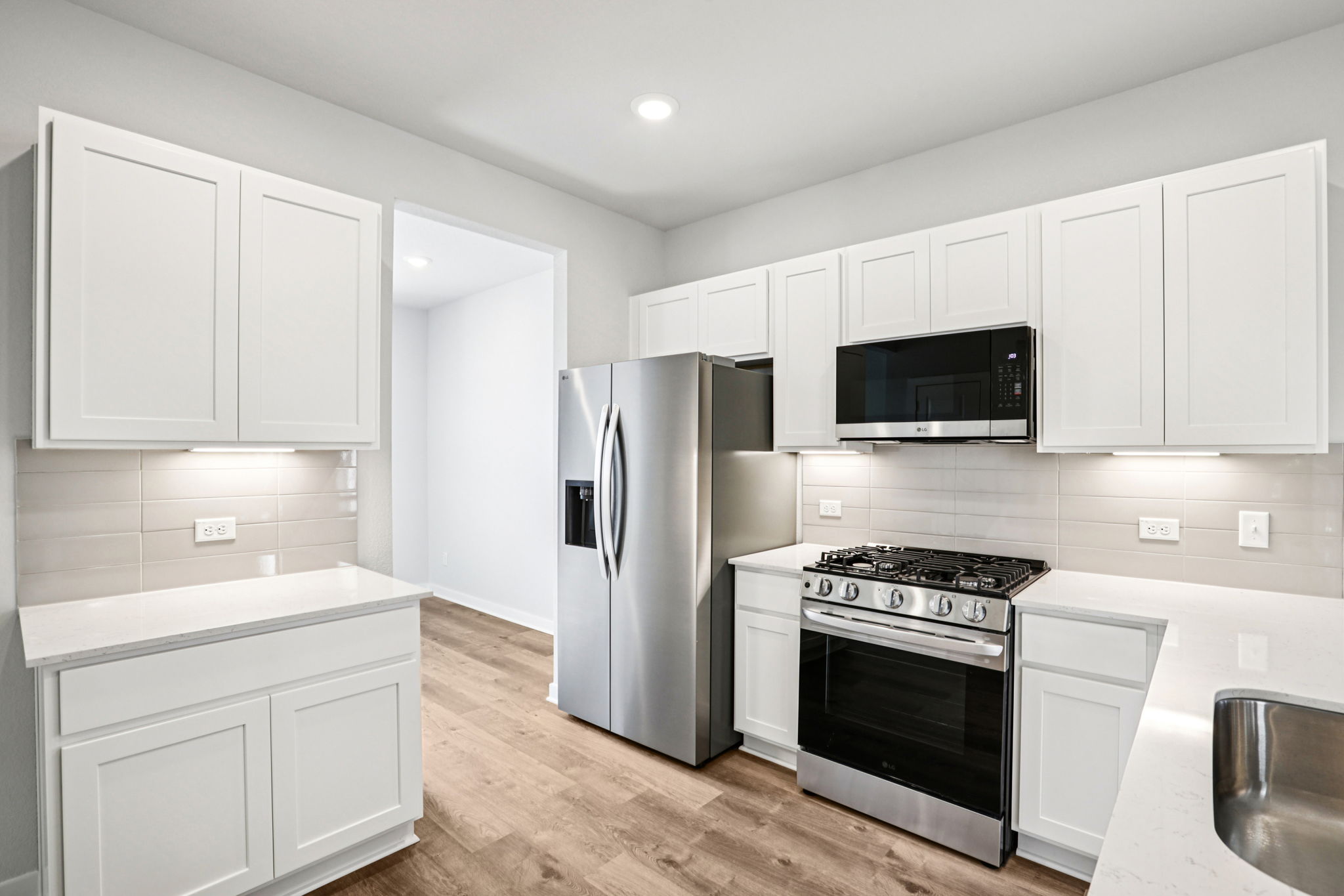 A kitchen with white cabinets.