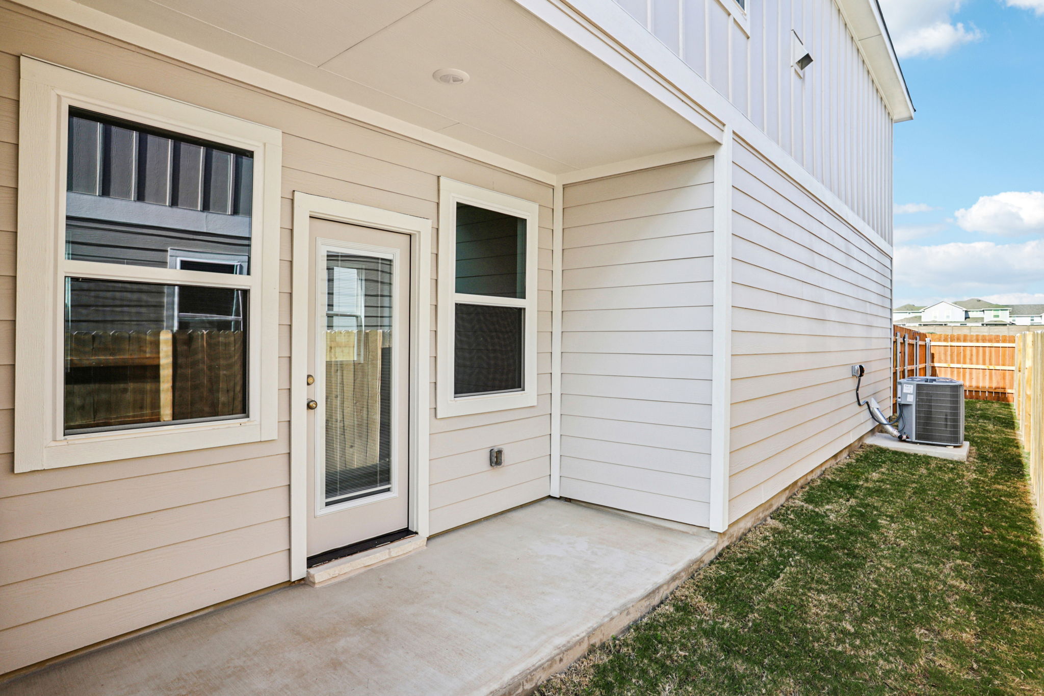 A white house with a green lawn.