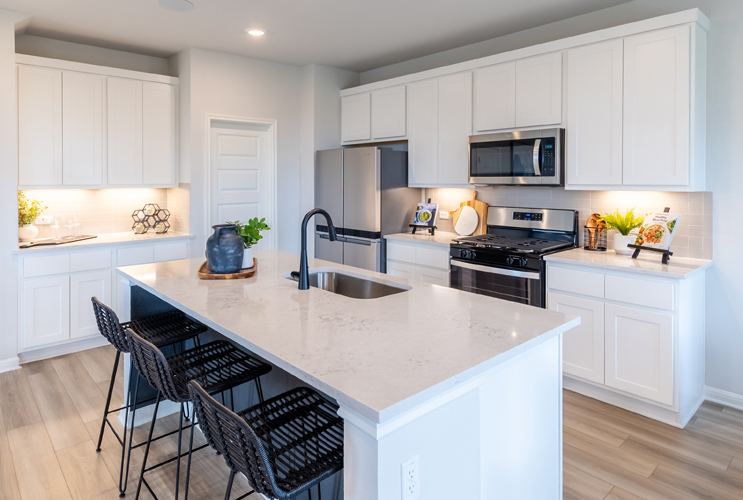 A kitchen with white cabinets.