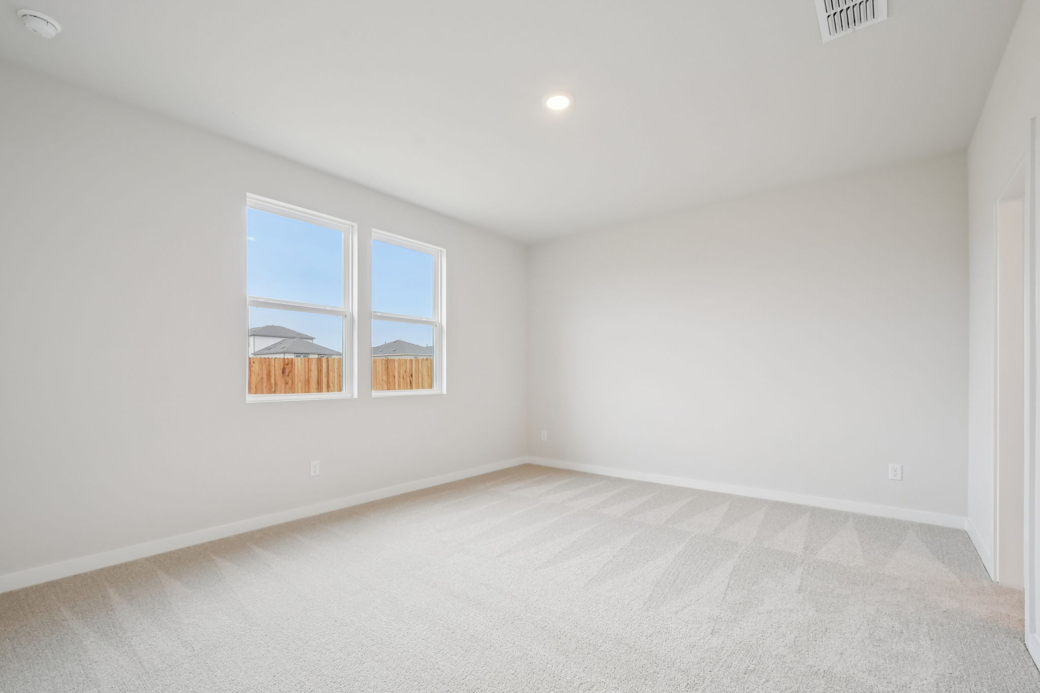 A room with a window and a white wall.