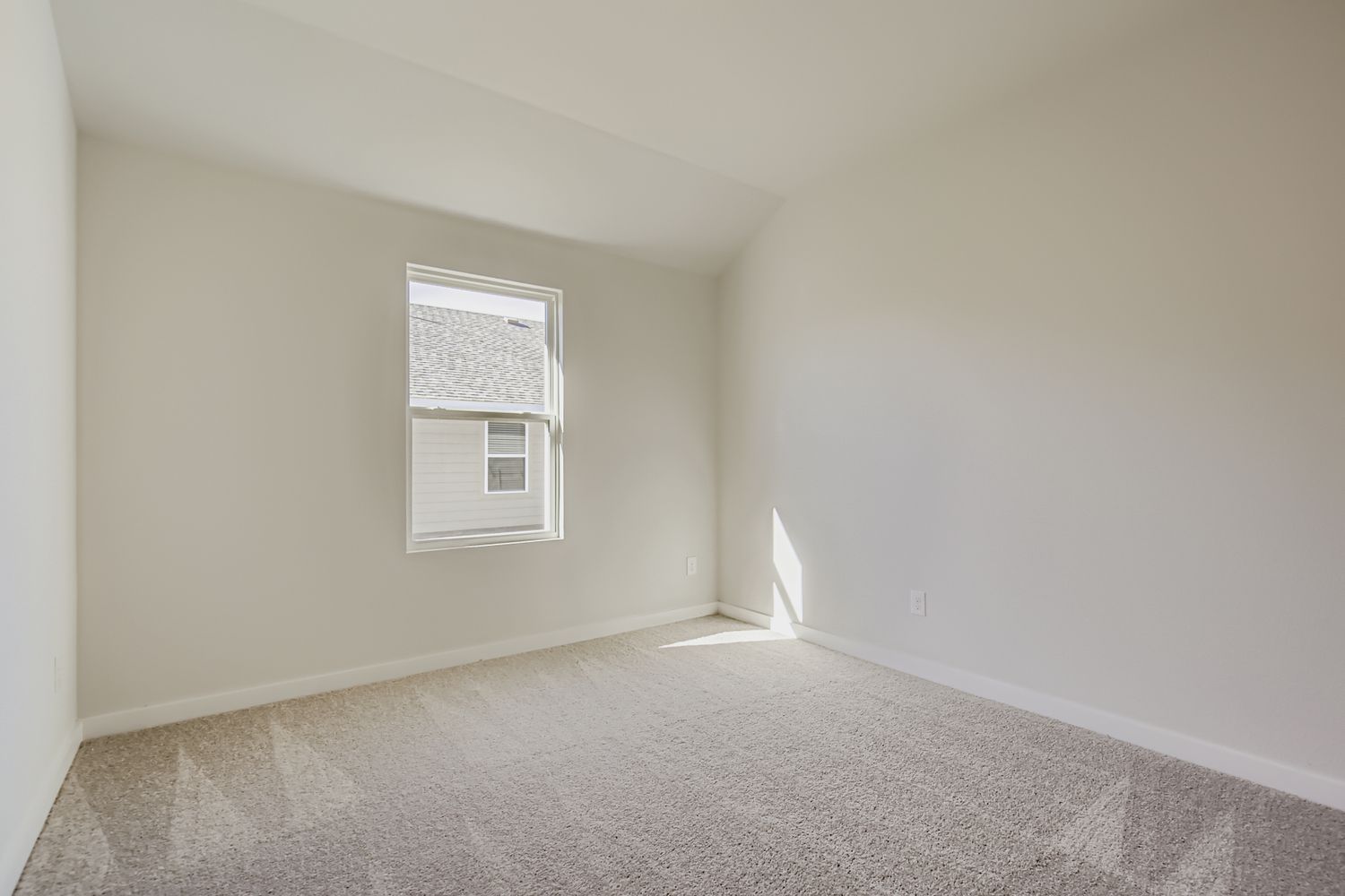 A room with a carpet and a window.