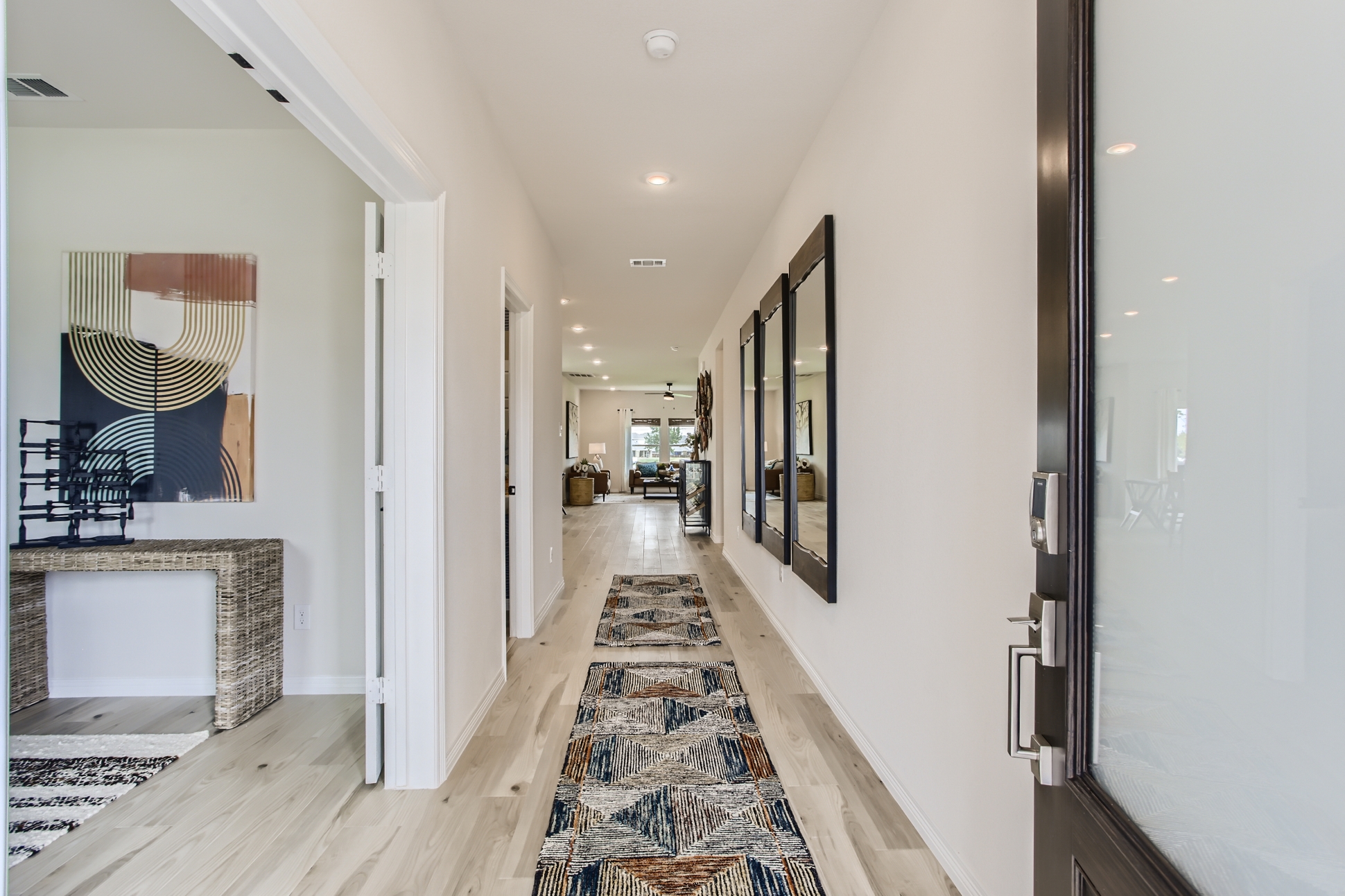 A hallway with a rug and a mirror.
