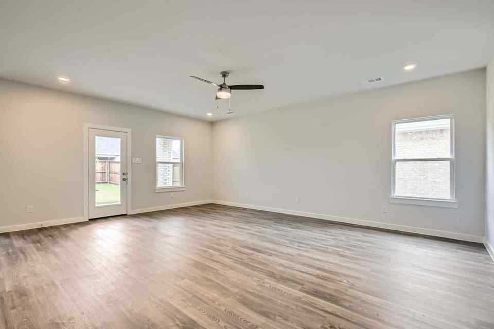 A room with a wood floor and a ceiling fan.