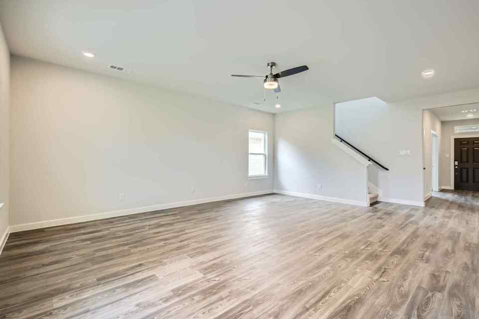 A room with a wood floor and a ceiling fan.