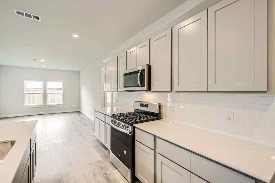 A kitchen with white cabinets.