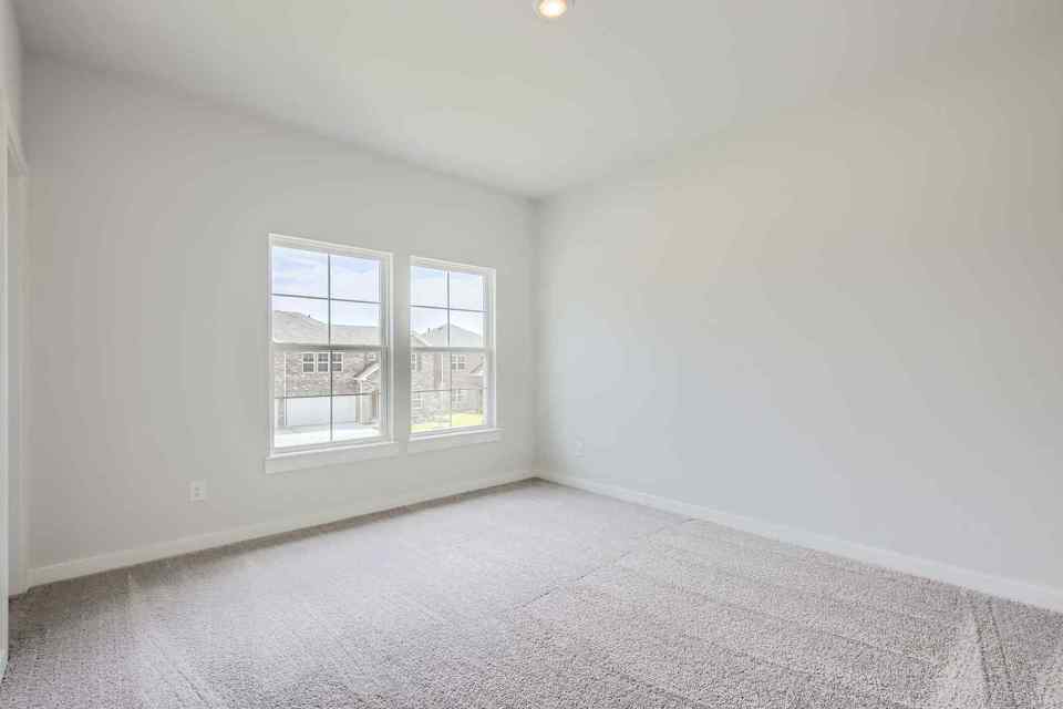A room with a window and a white wall.