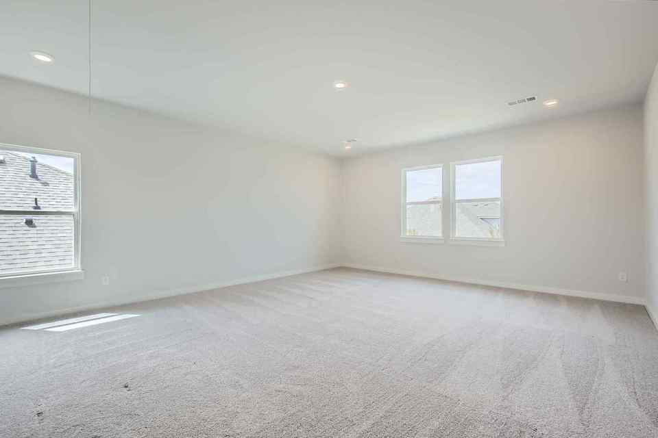 A room with a carpet and windows.