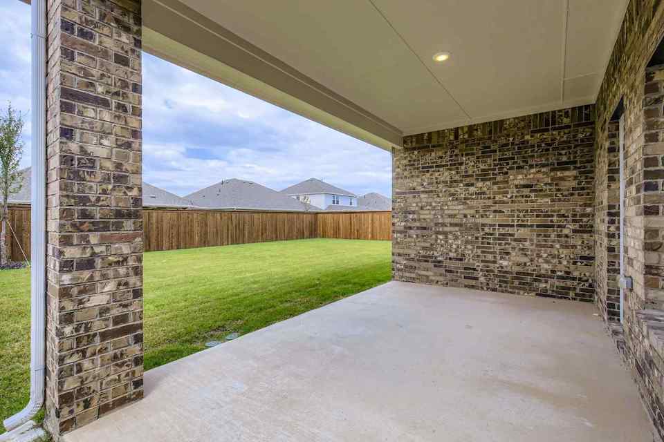 A walkway with grass and a fence.