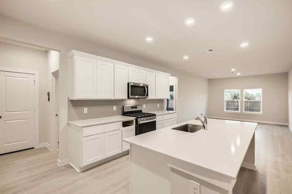 A kitchen with white cabinets.