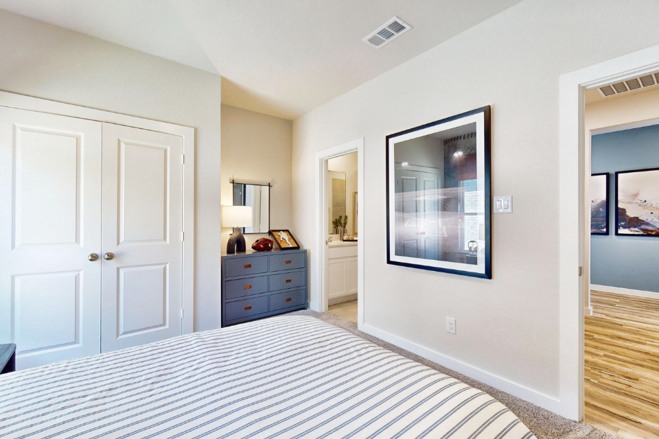 A room with white walls and a dresser with a mirror on it.