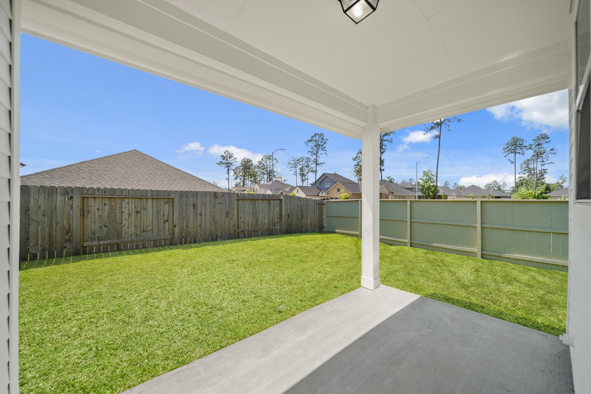 A fenced in yard with a house and a walkway.