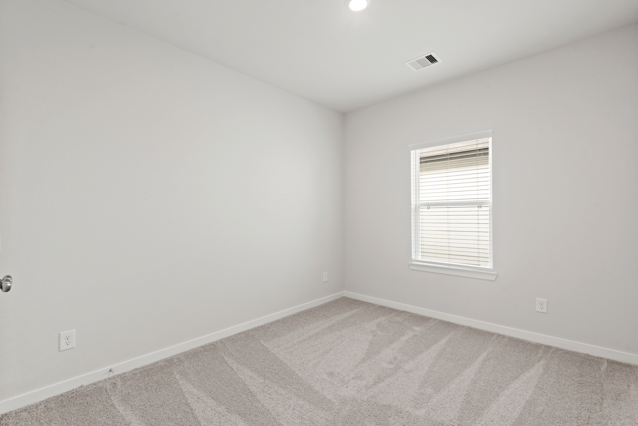 A room with a carpet and a window.