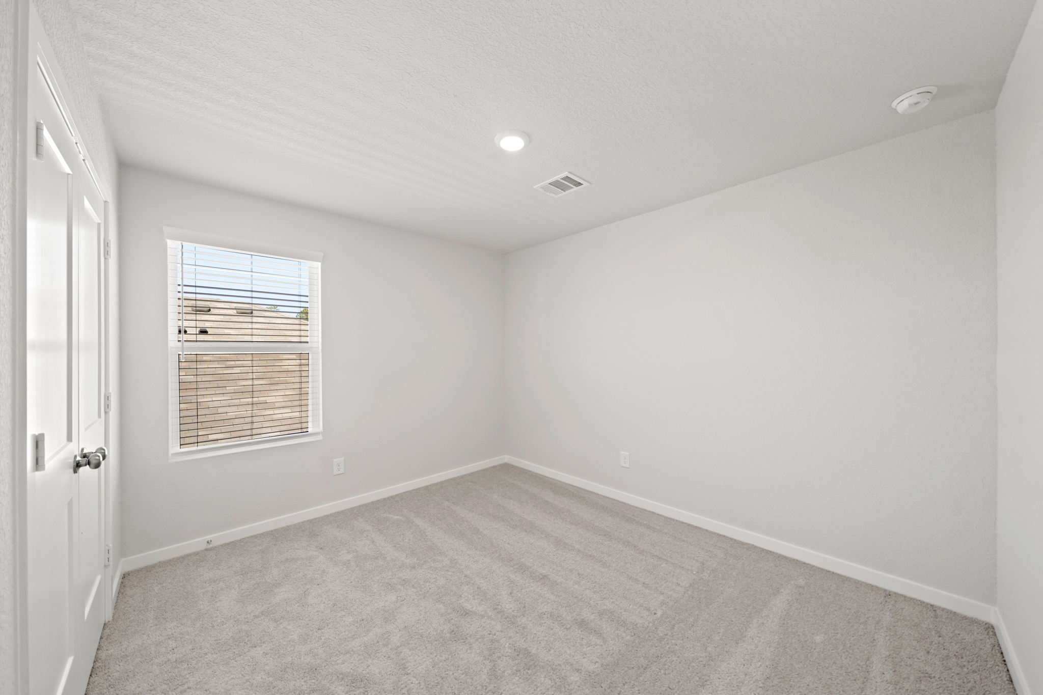 A room with a carpet and a window.