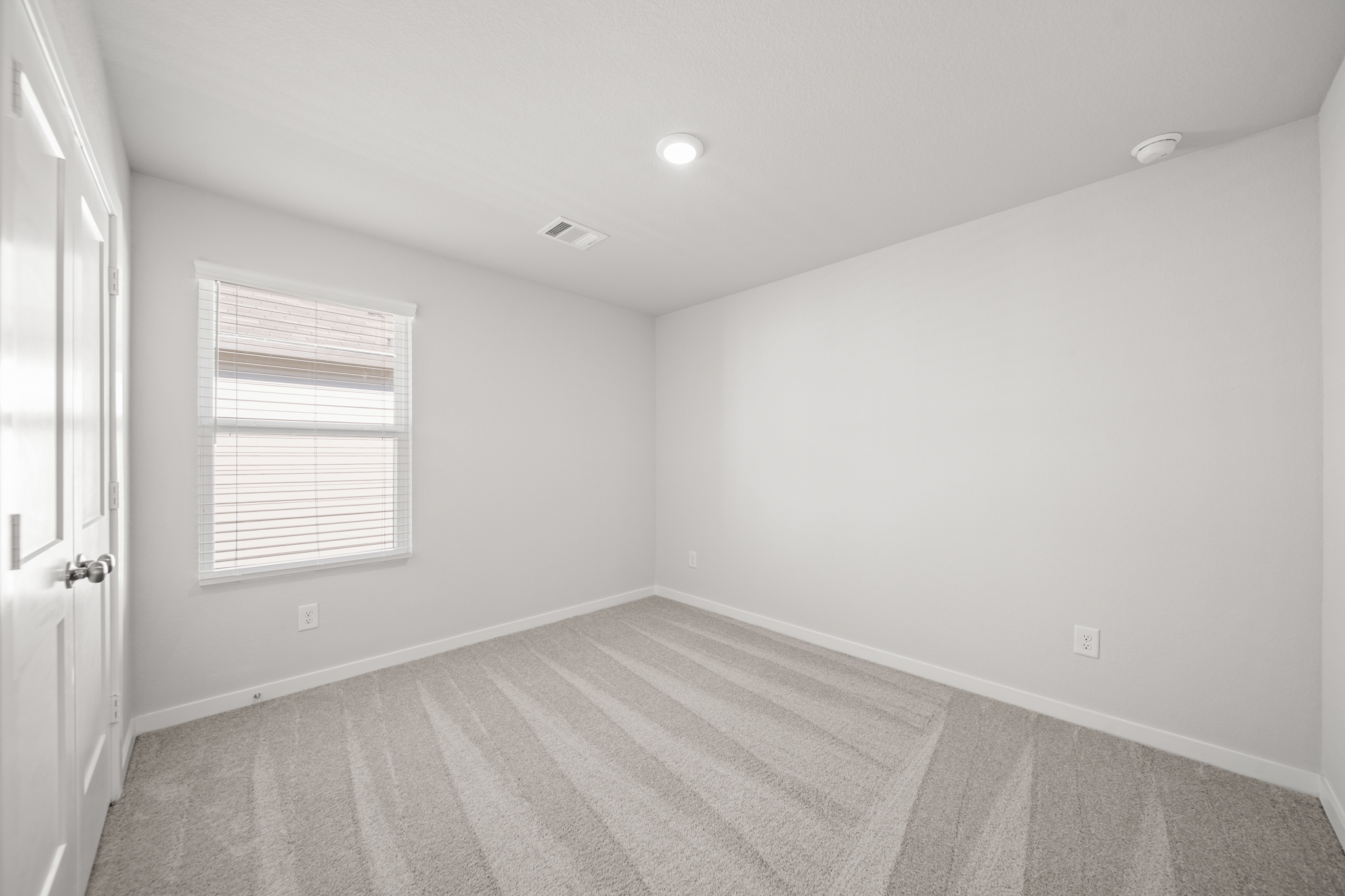 A room with a carpet and a window.