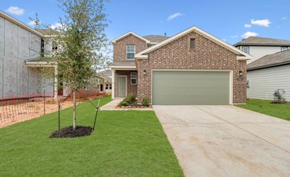 A brick house with a green lawn.