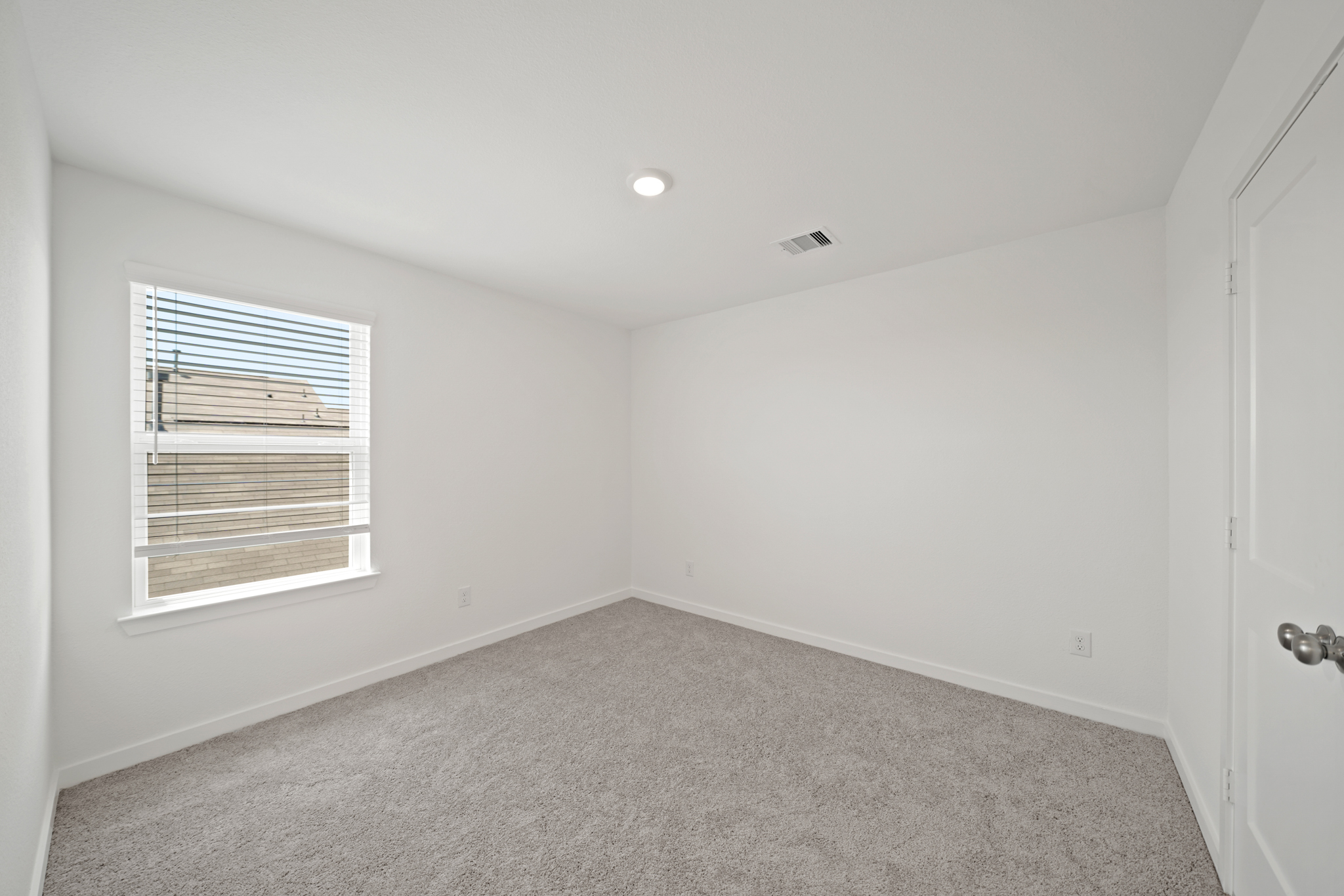 A room with a window and a carpet.