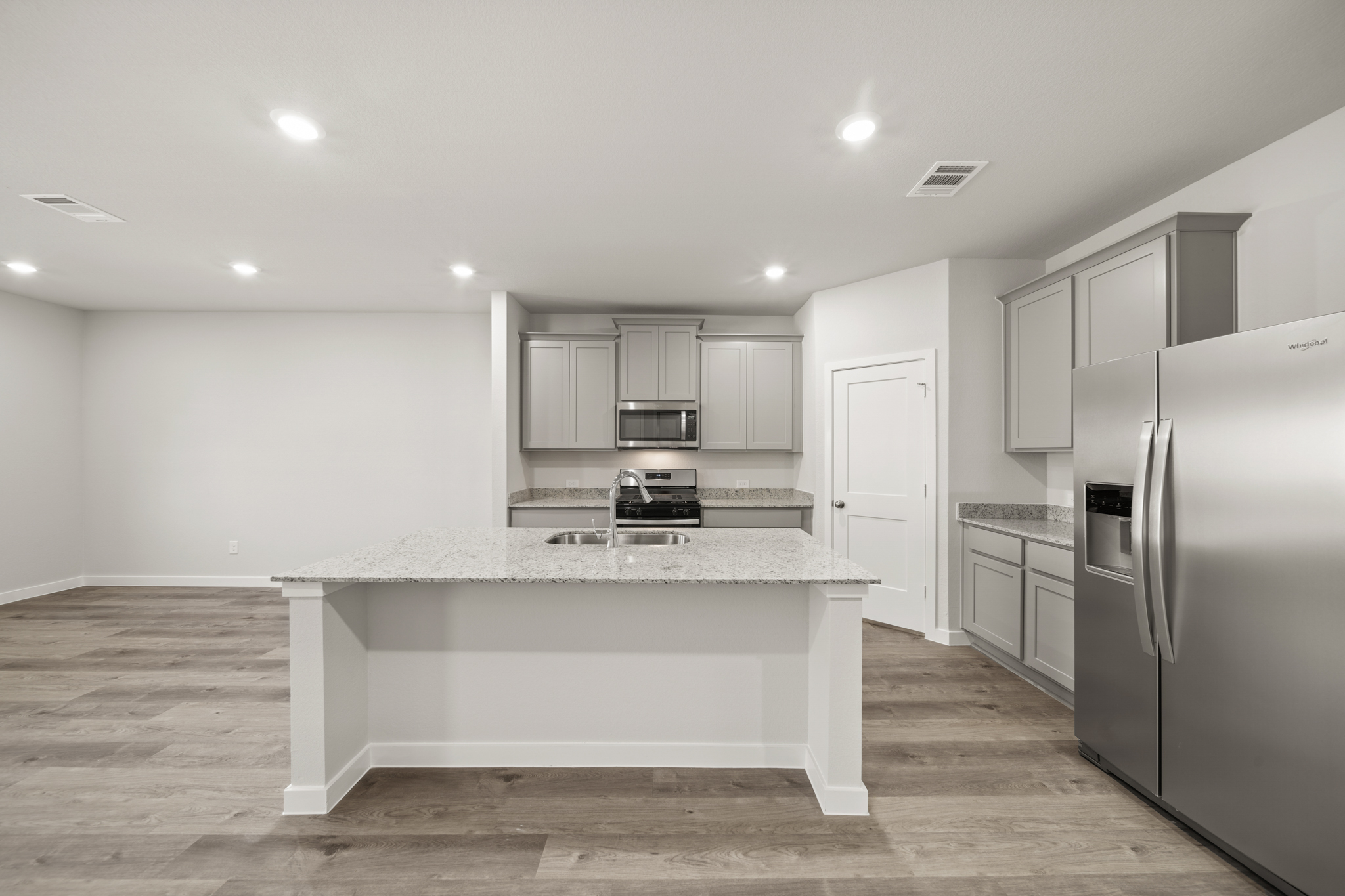 A kitchen with white cabinets.