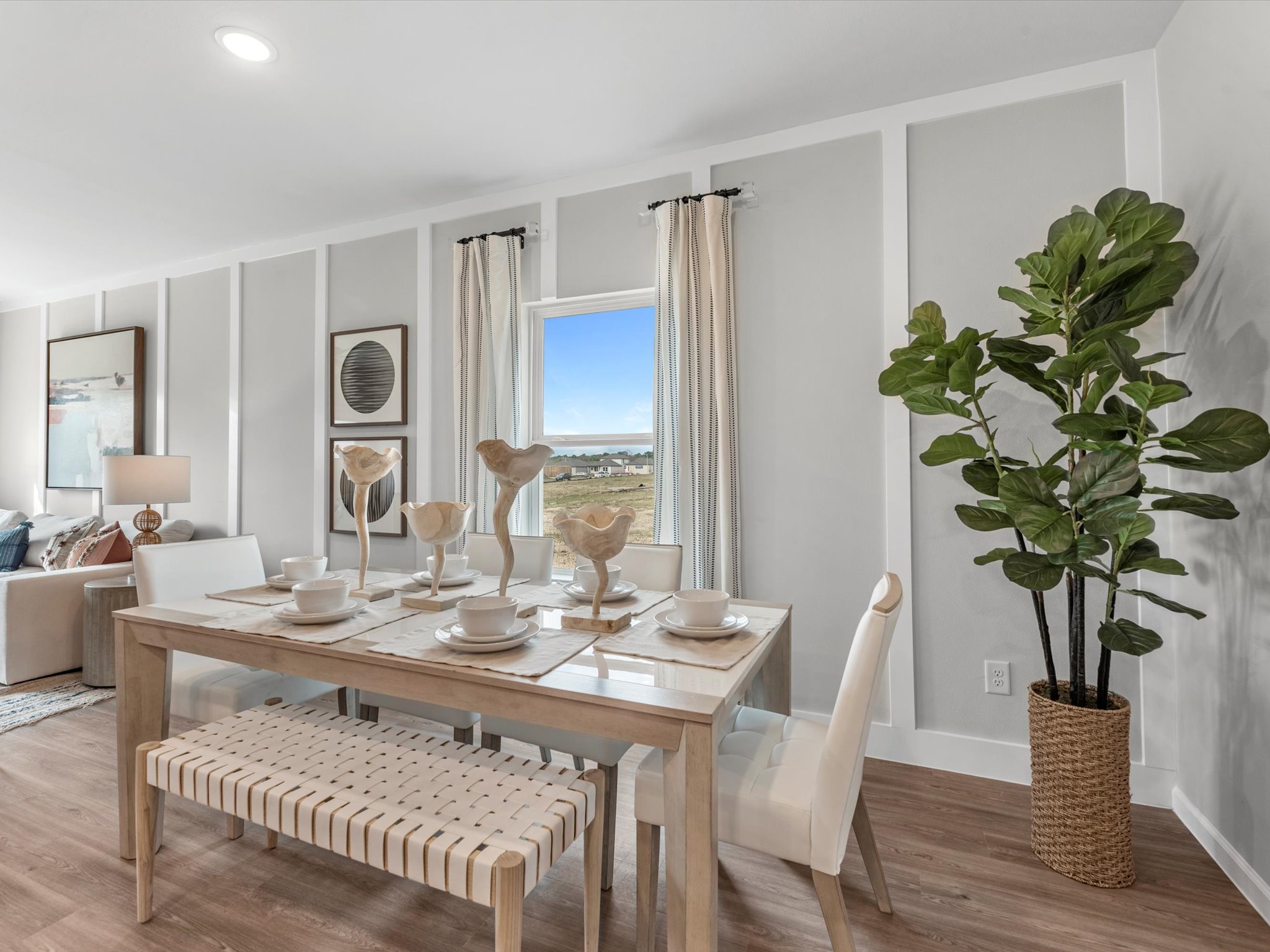 A dining room table with a vase of flowers on it.