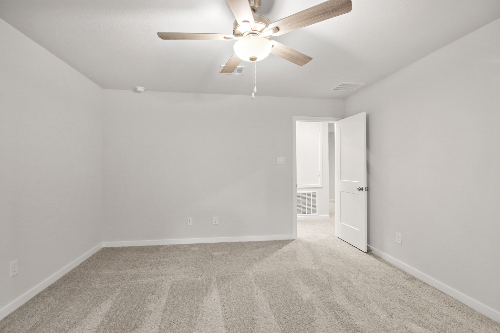 A room with a ceiling fan and a door.
