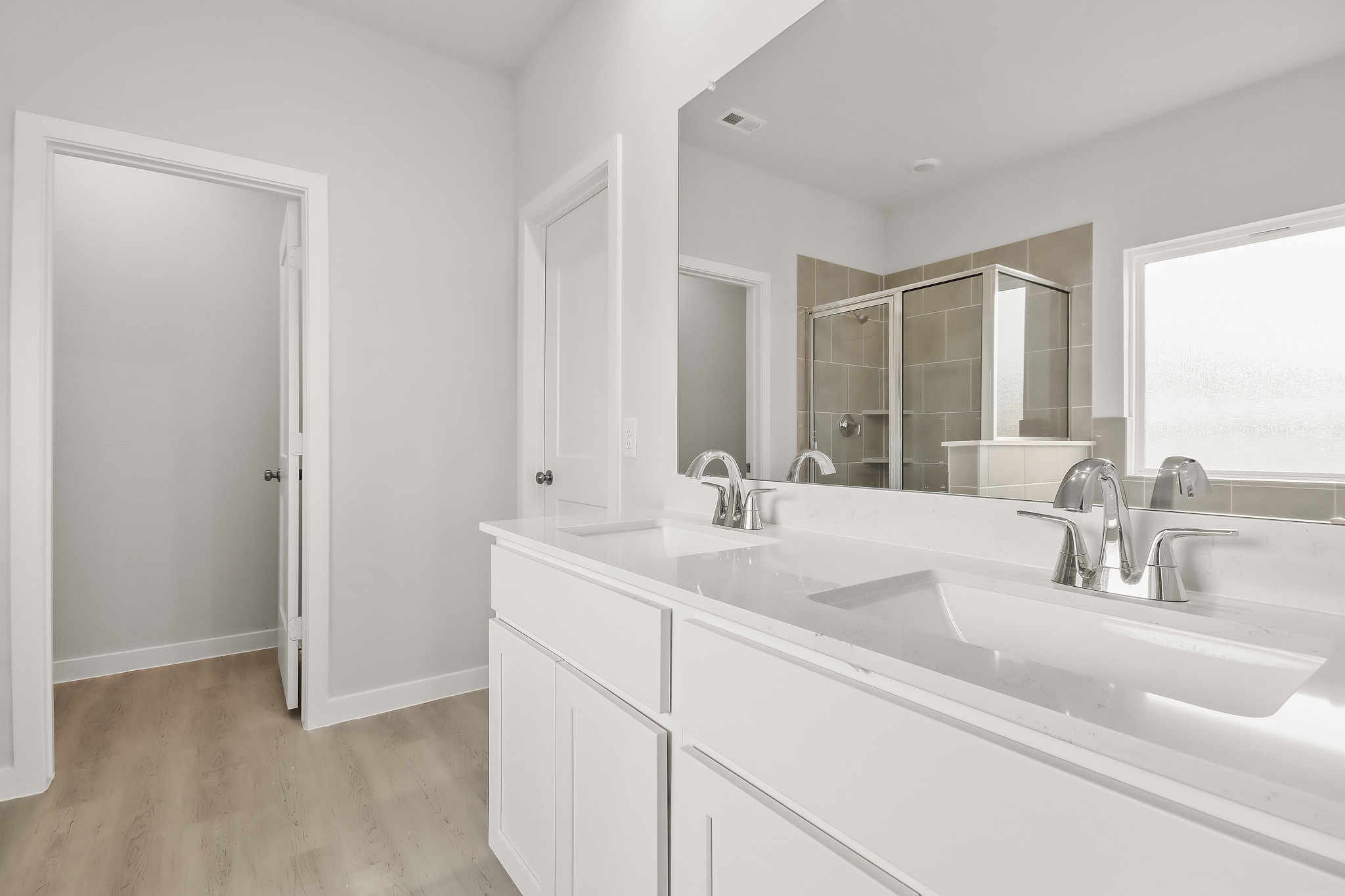 A bathroom with white cabinets.