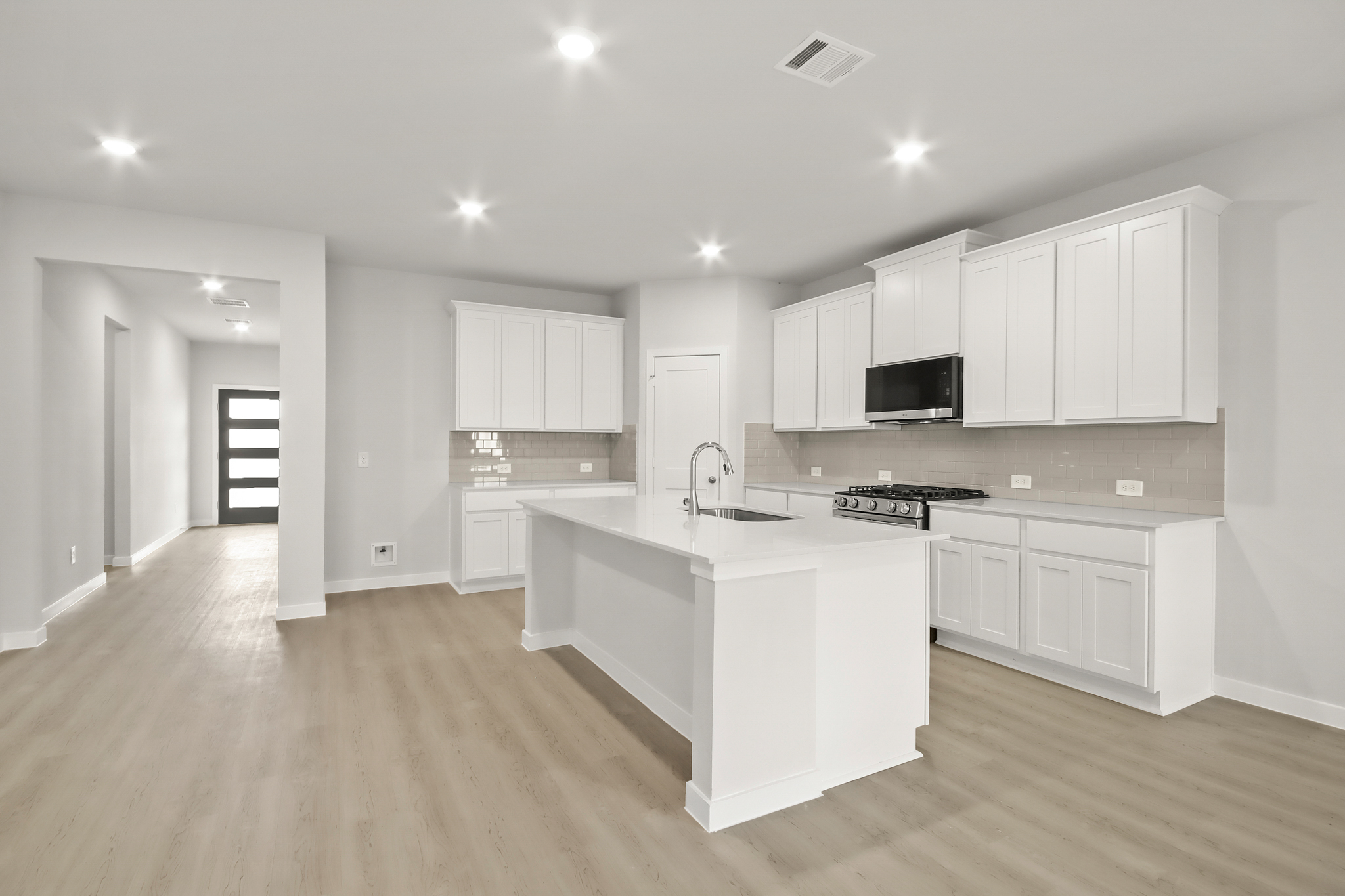 A kitchen with white cabinets.