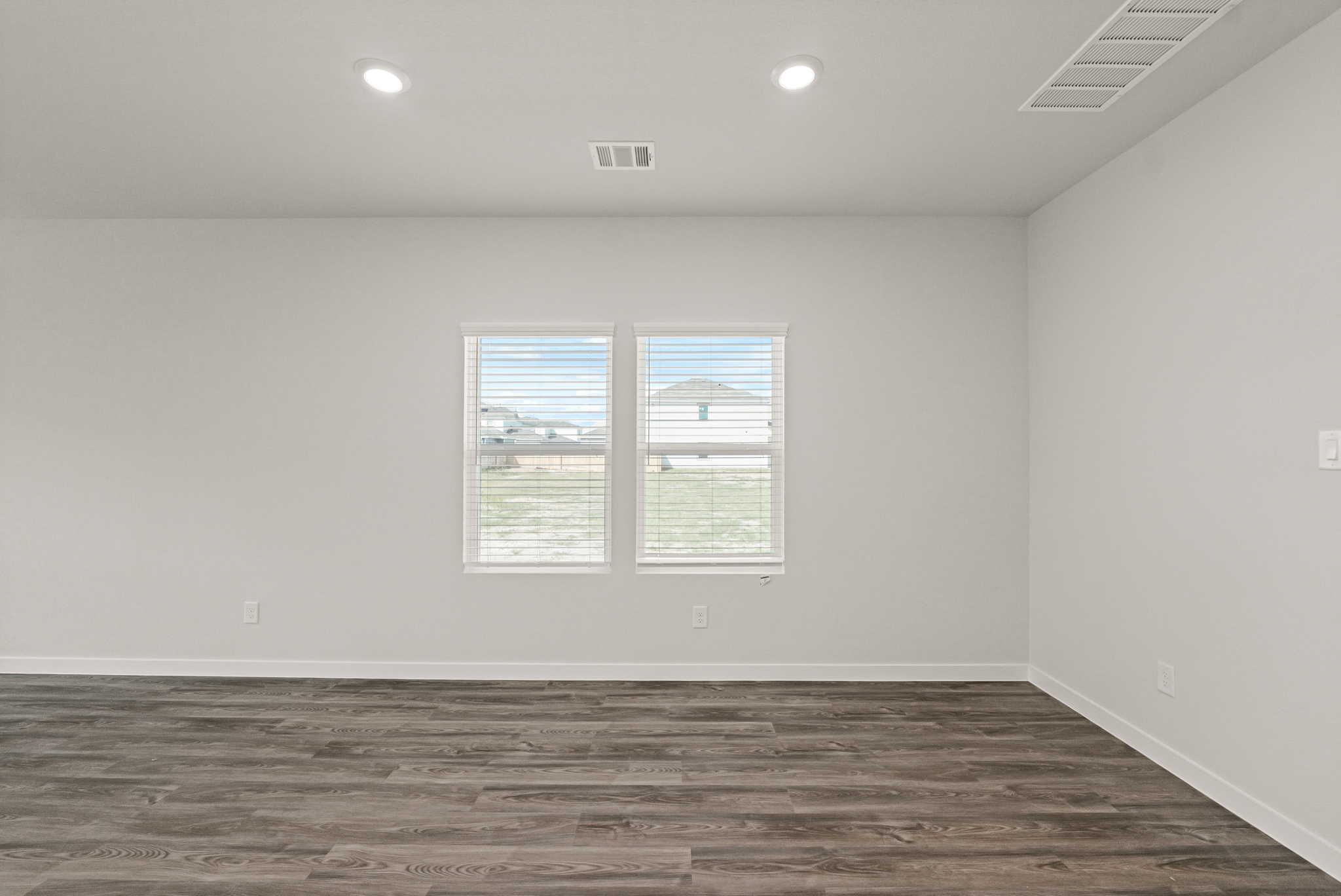 A room with a wood floor and white walls.