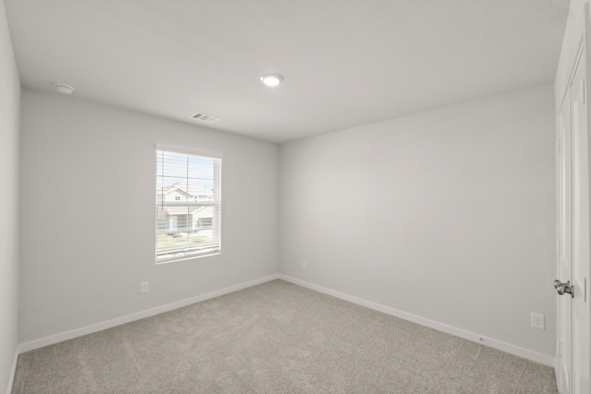 A room with a window and a carpet.