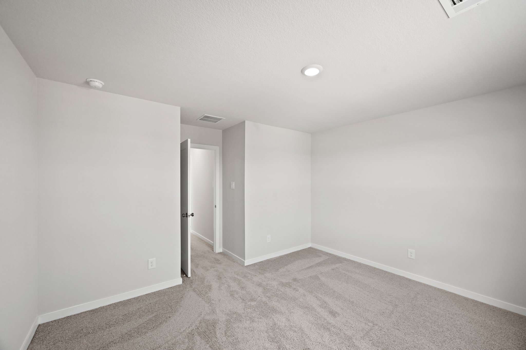 A room with a carpet and a door.