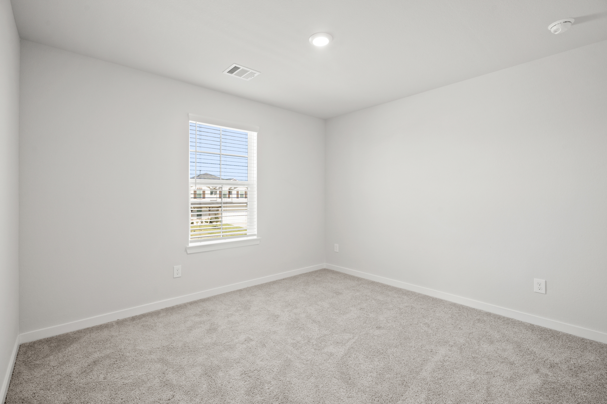 A room with a window and a carpet.