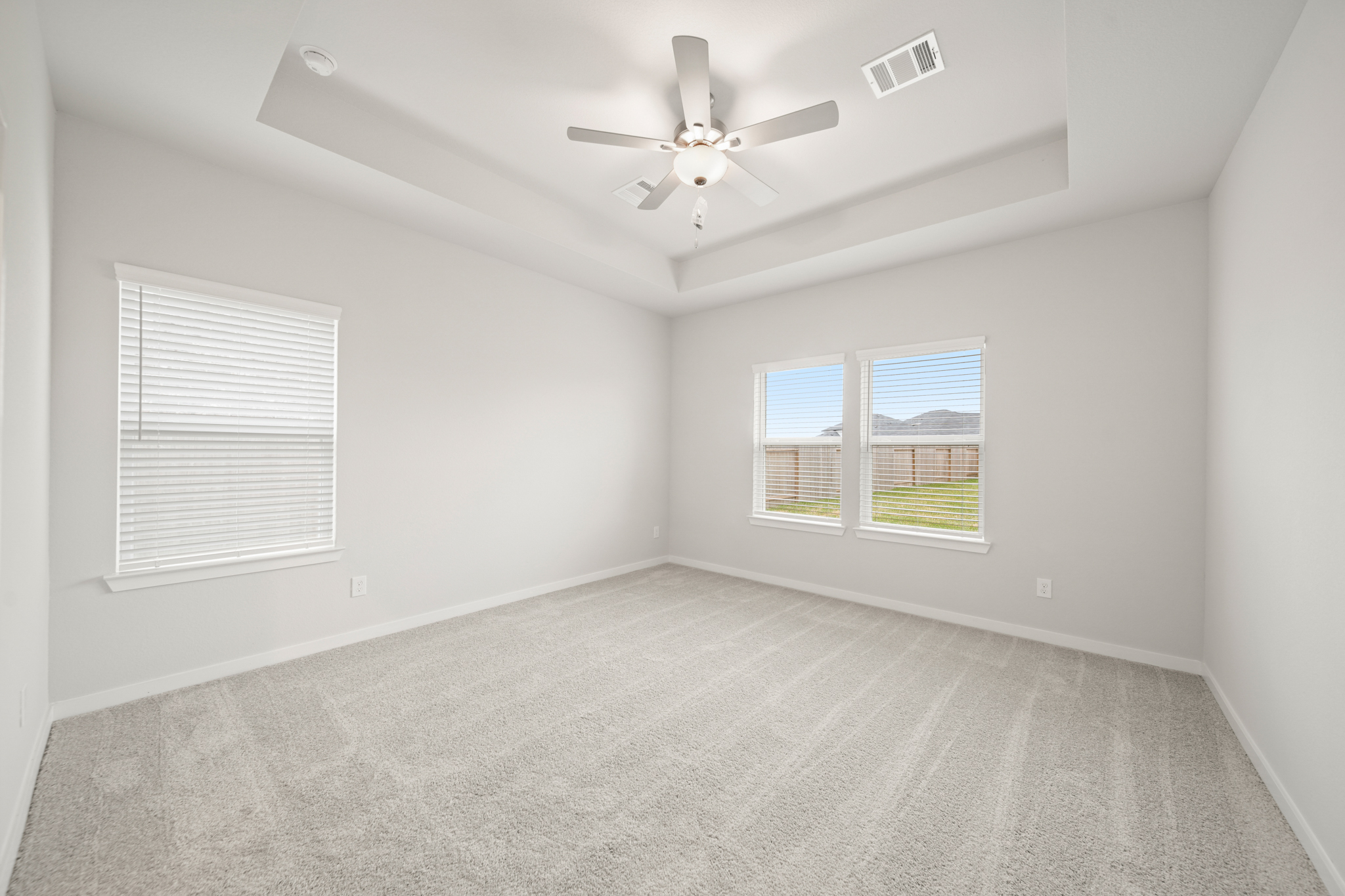 A room with a ceiling fan and a window.