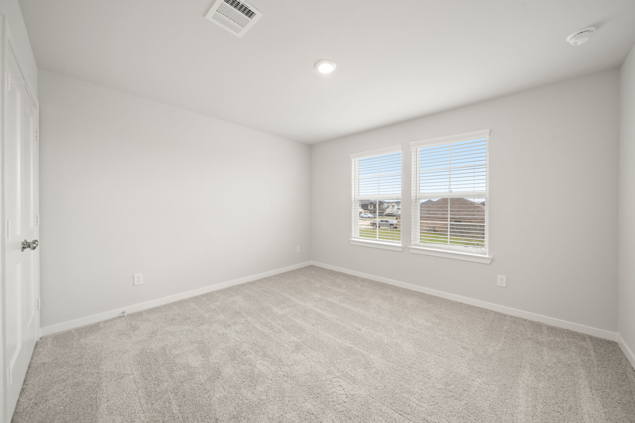 A room with a window and a carpet.