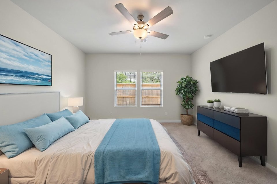 A bedroom with a bed and a fan.