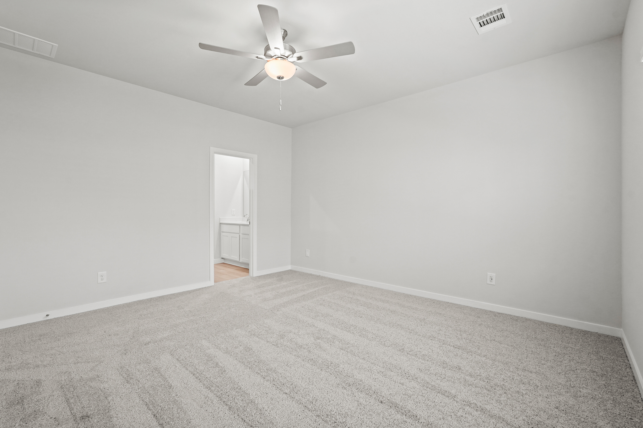 A room with a ceiling fan and a door.