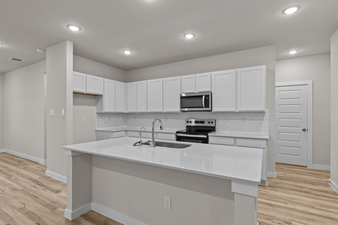 A kitchen with white cabinets.