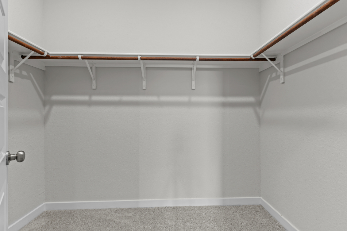 A white wall with a metal bar.