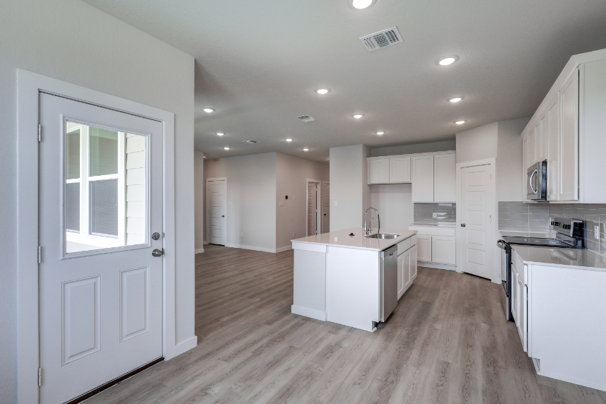 A kitchen with white cabinets.