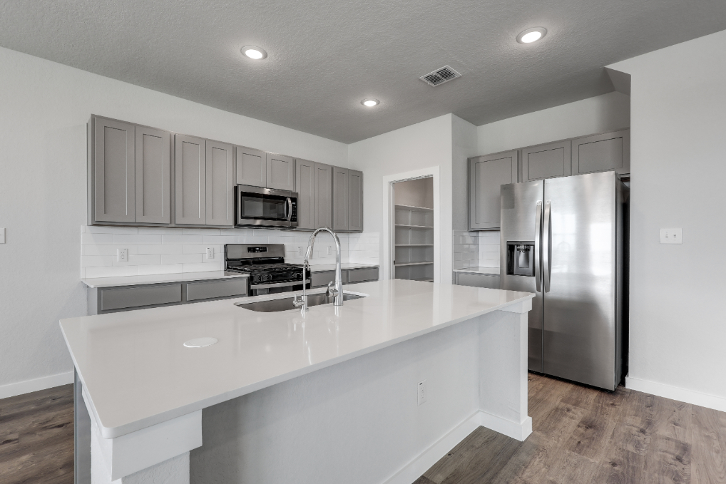 A kitchen with white cabinets.