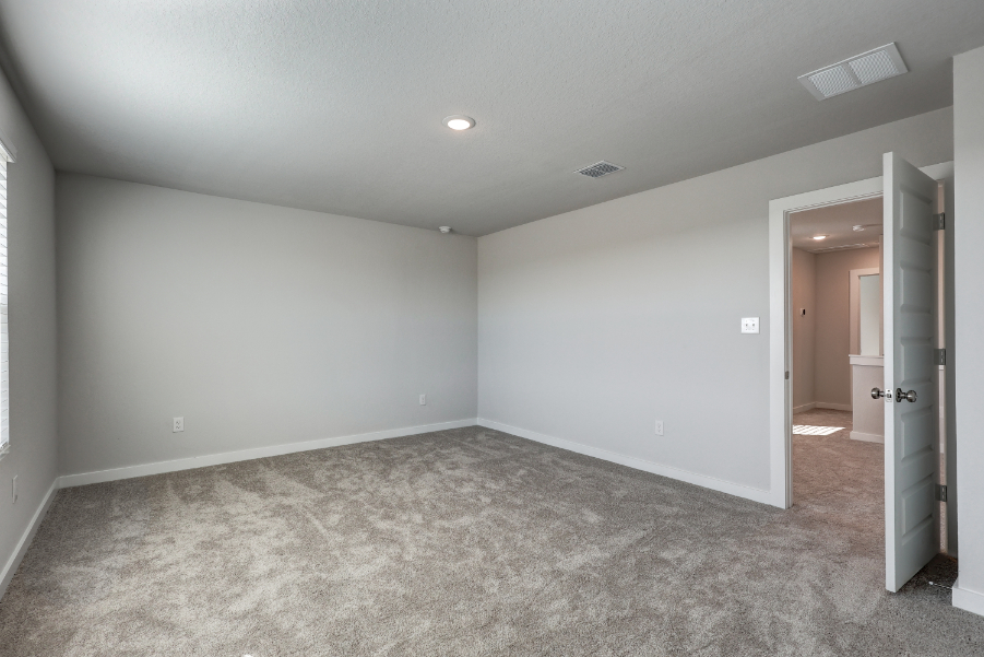 A room with a carpet and a door.