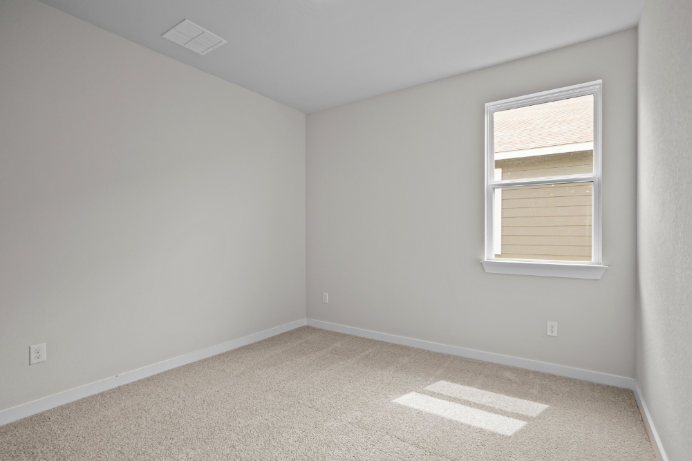 A room with a window and carpet.