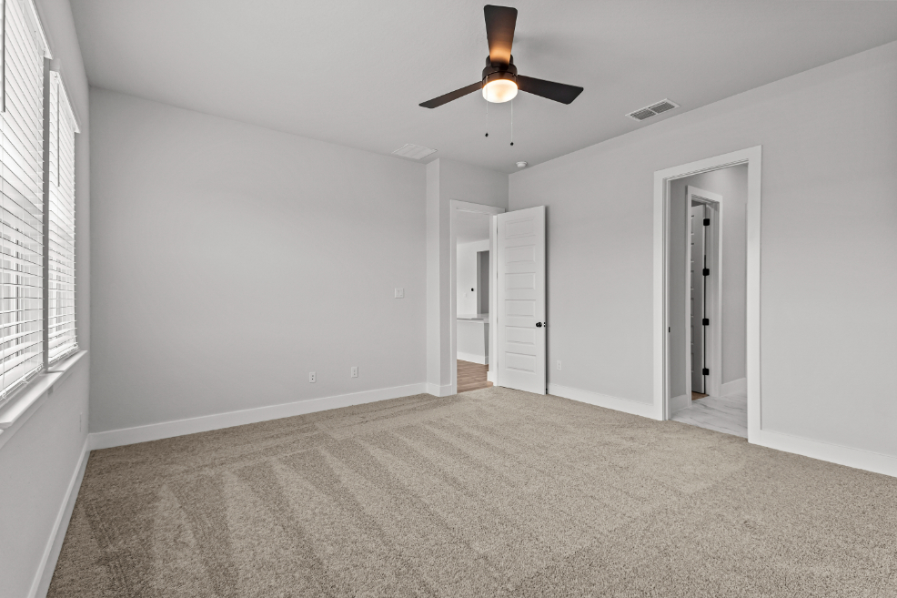 A room with a ceiling fan and a door.