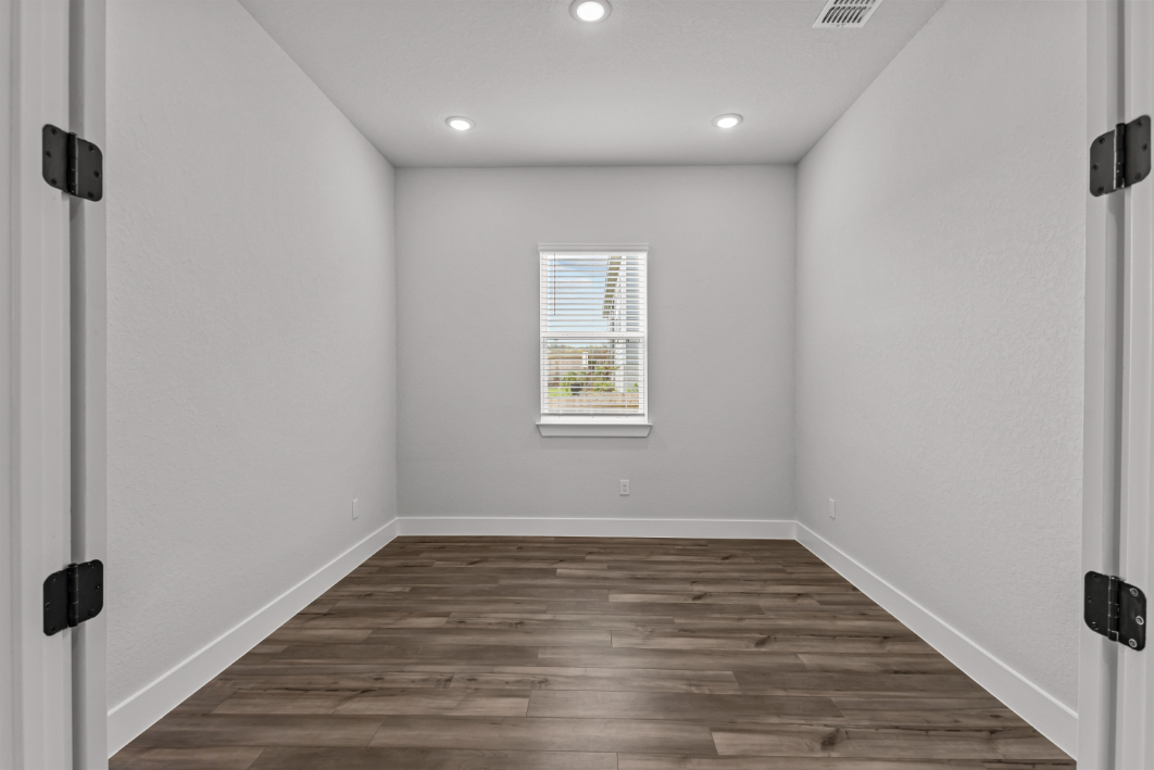 A room with a wood floor and white walls.