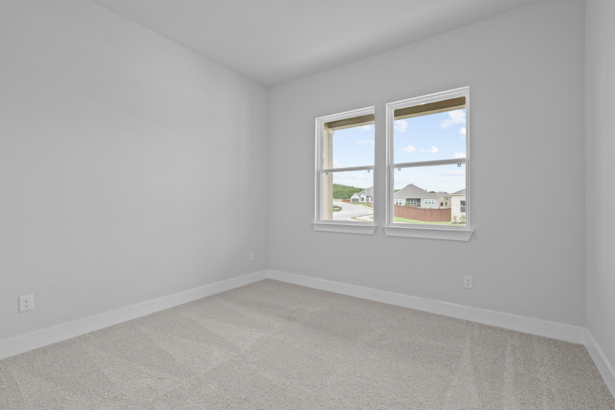 A room with a window and a carpet.