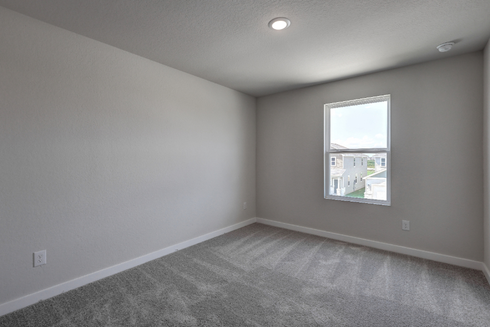 A room with a window and a carpet.
