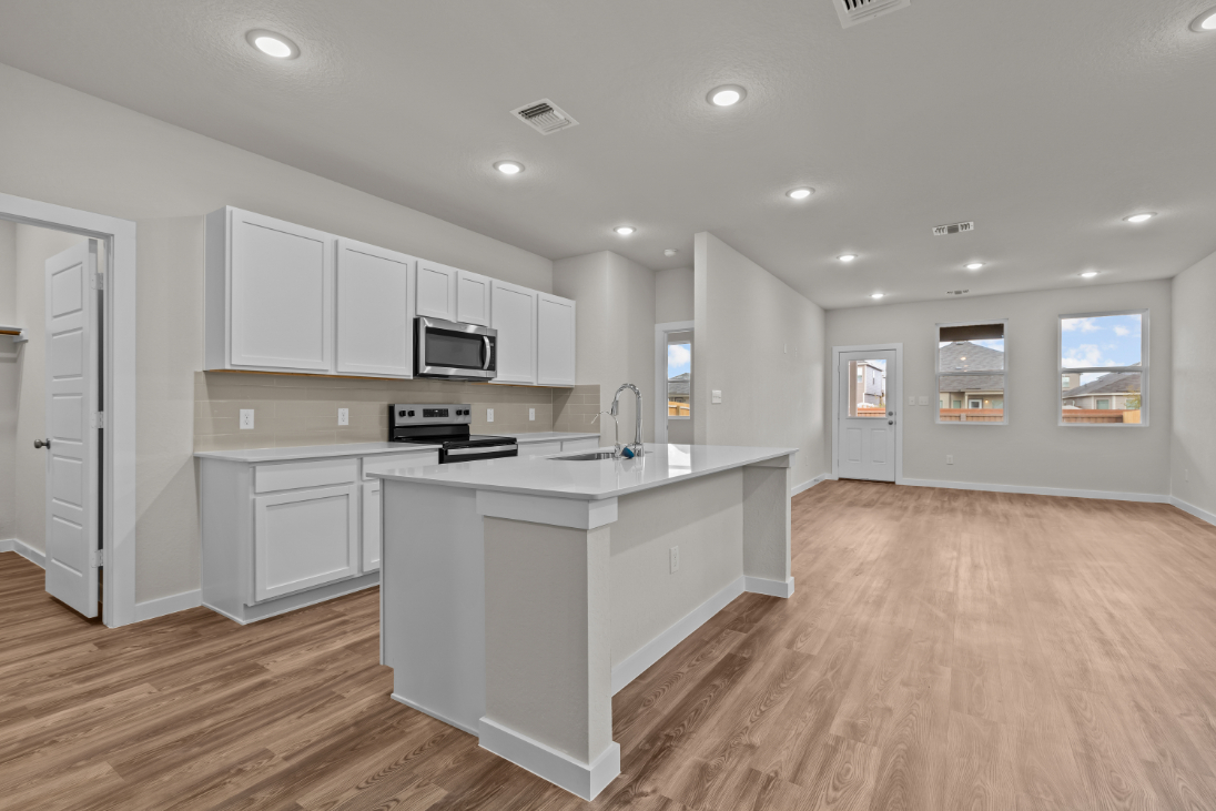 A kitchen with white cabinets.