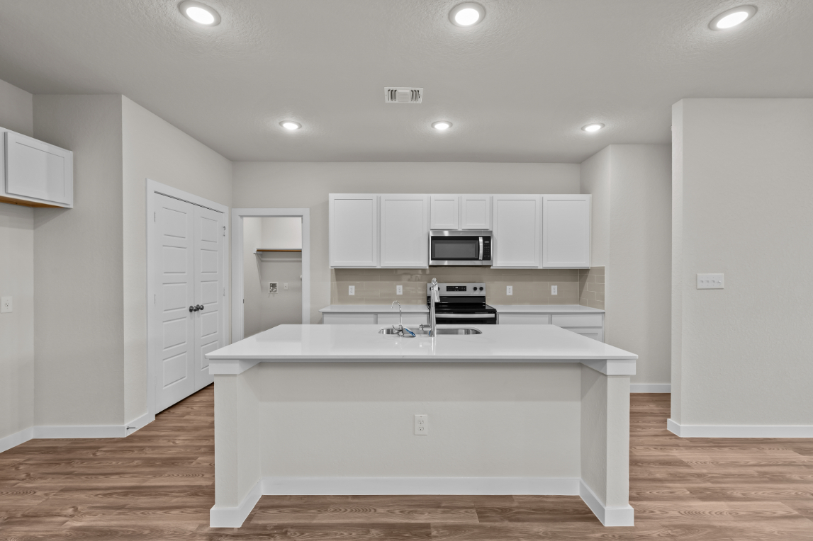 A kitchen with white cabinets.