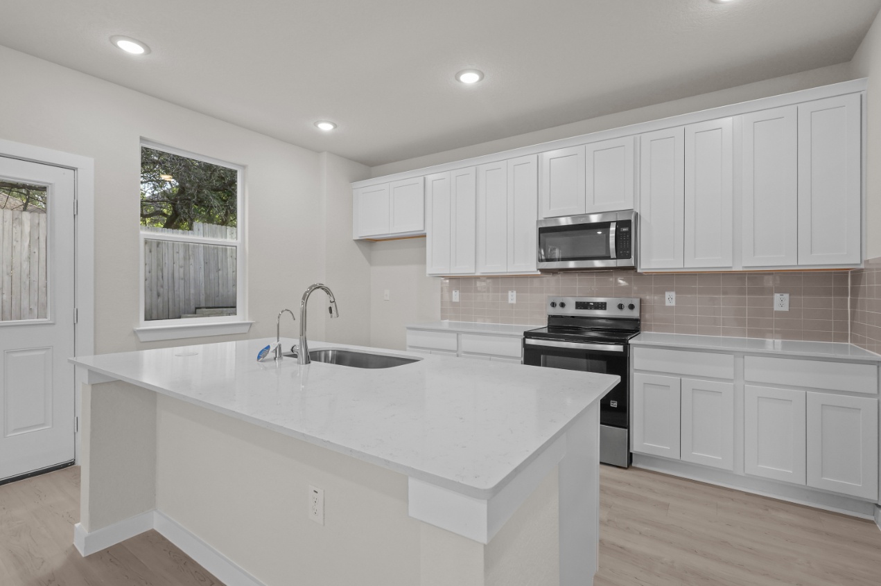 A kitchen with white cabinets.