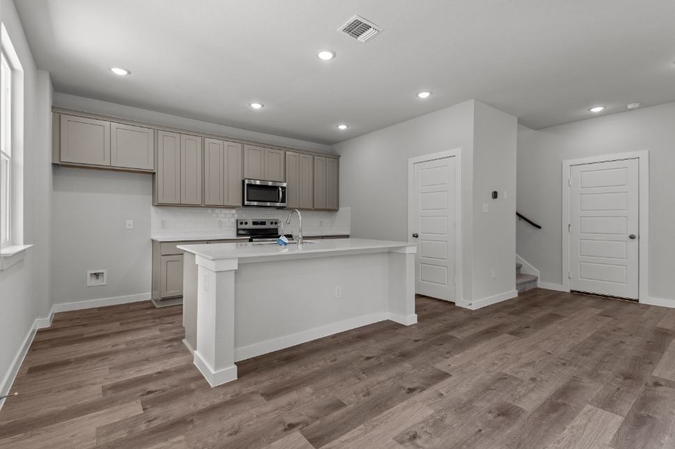A kitchen with white cabinets.
