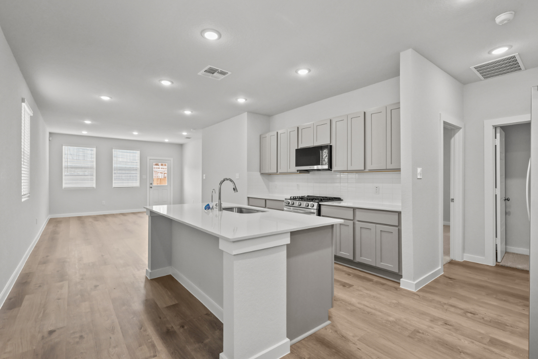 A kitchen with white cabinets.