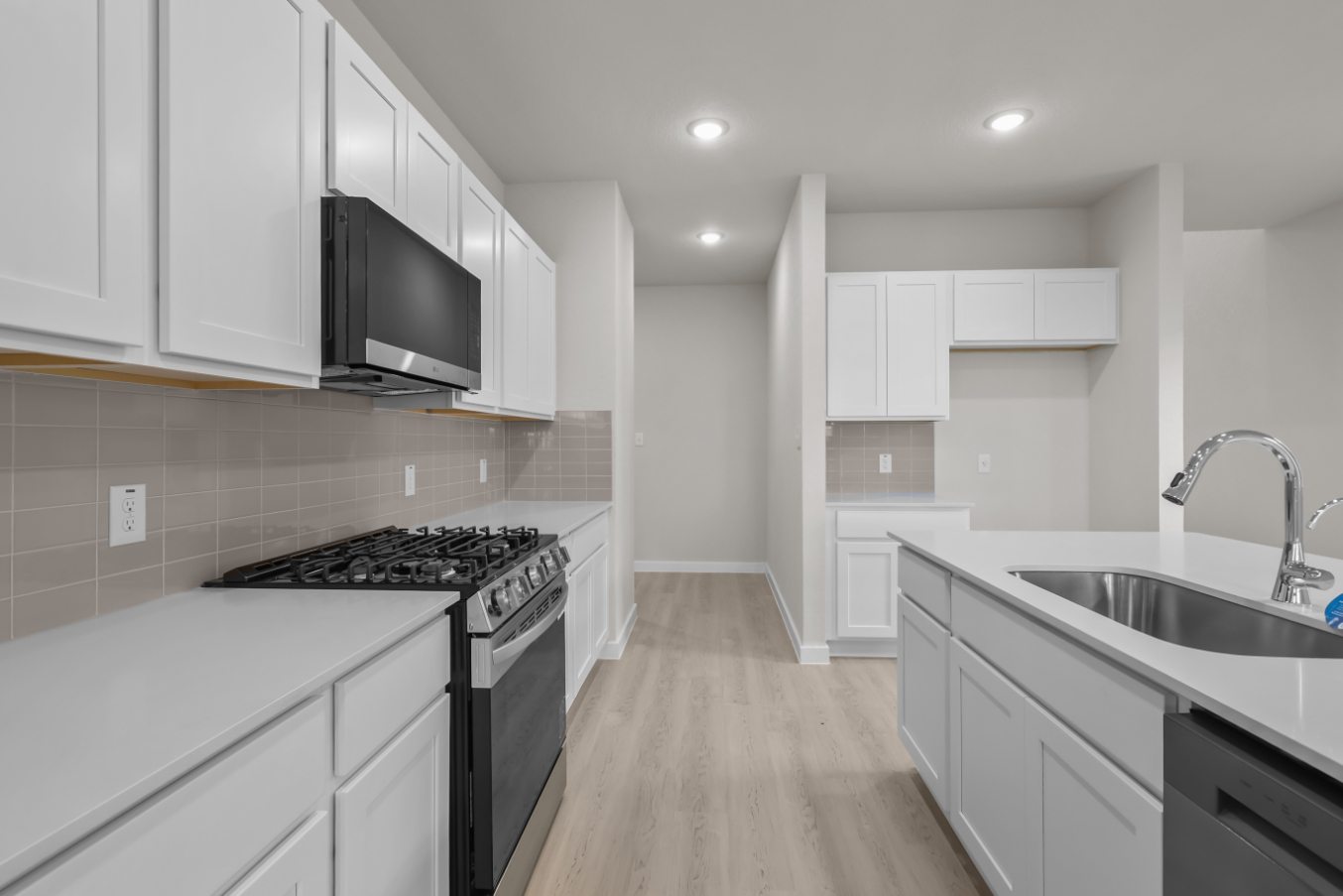 A kitchen with white cabinets.
