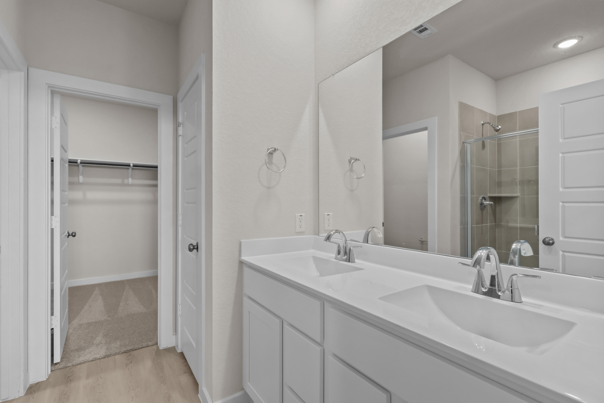 A bathroom with a sink and a shower unit.